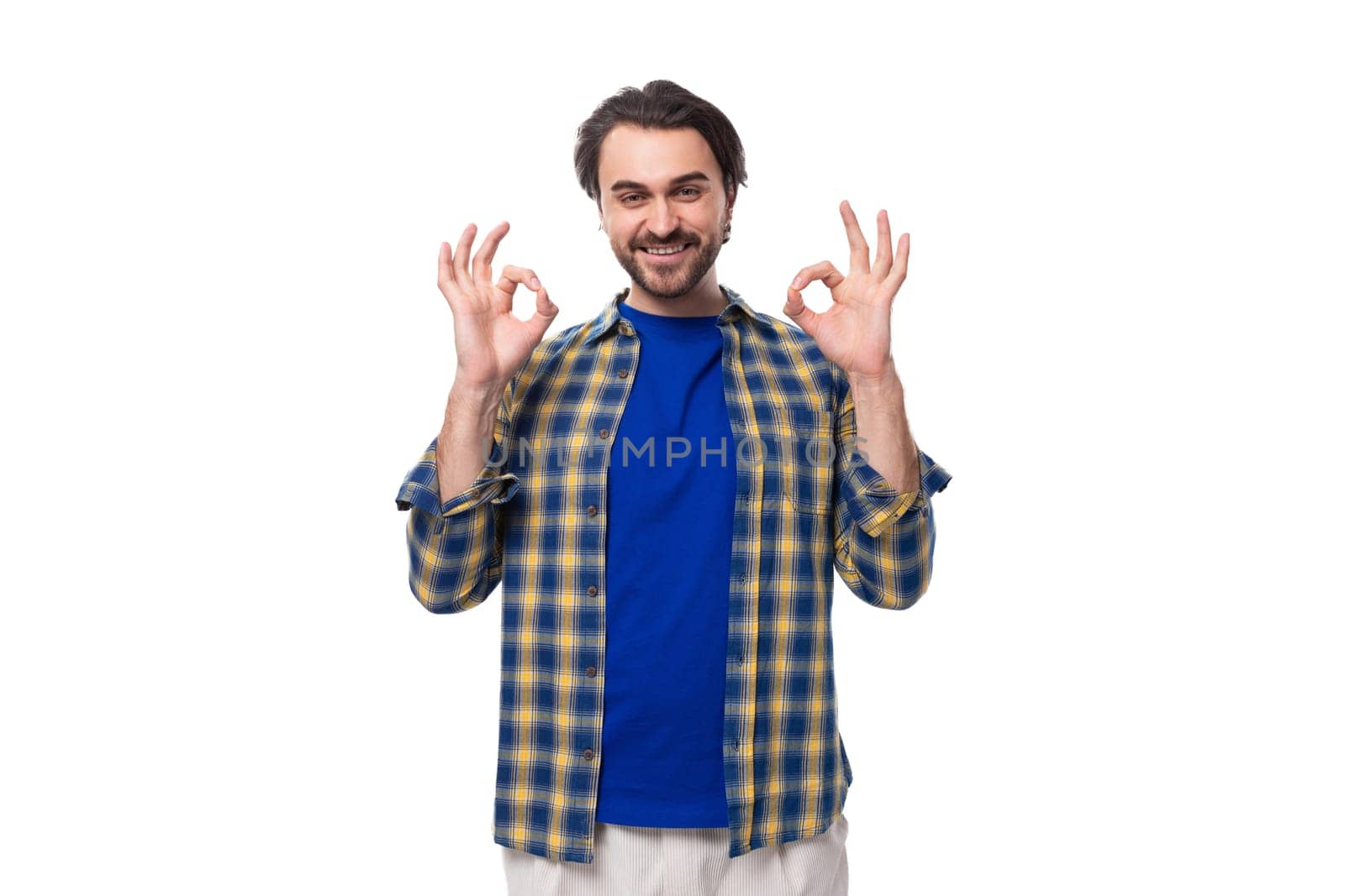 a young Caucasian brutal man with an unshaven face dressed in a blue plaid shirt shows that everything is ok.