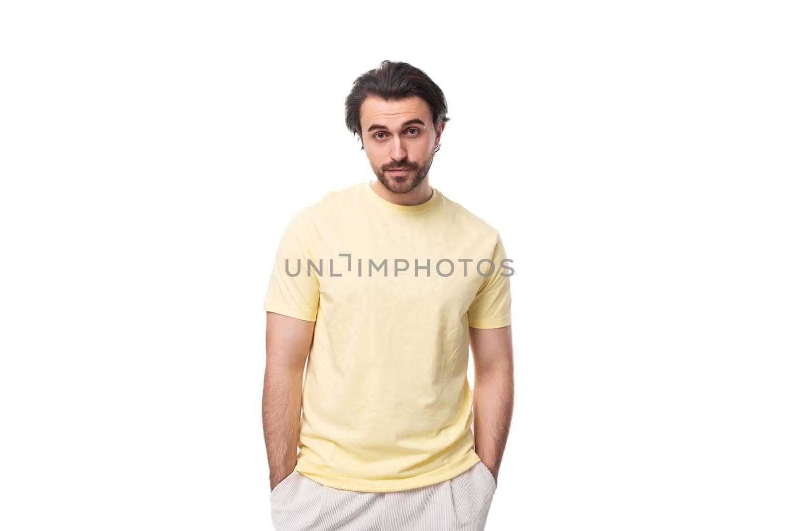 caucasian brutal charming guy with a beard dressed in a summer t-shirt on a white background with copy space.