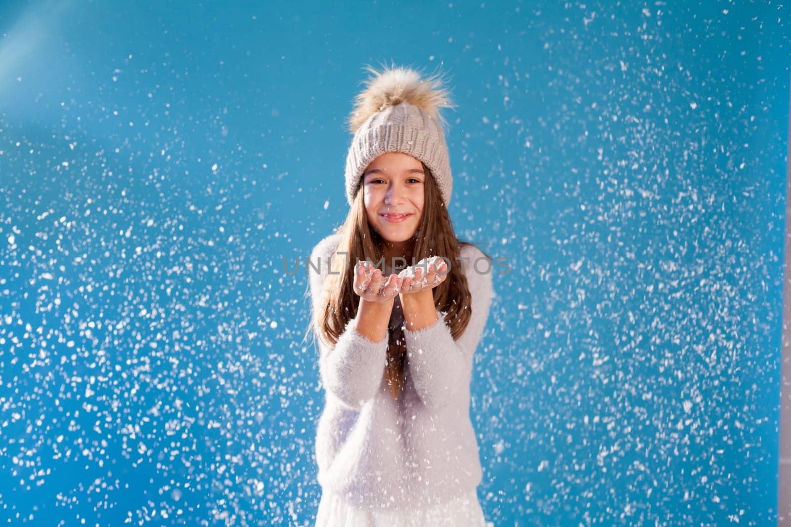 beautiful girls in winter hats and warm clothes playing with snow