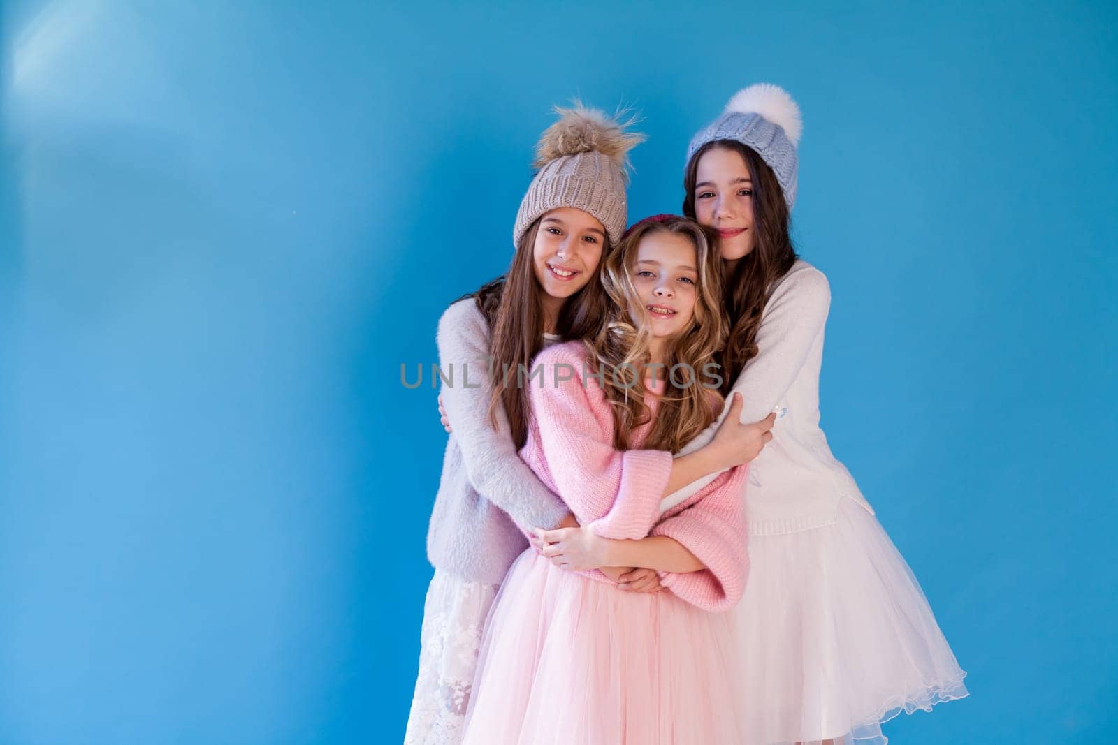 three beautiful girls in winter hats and warm clothes by Simakov