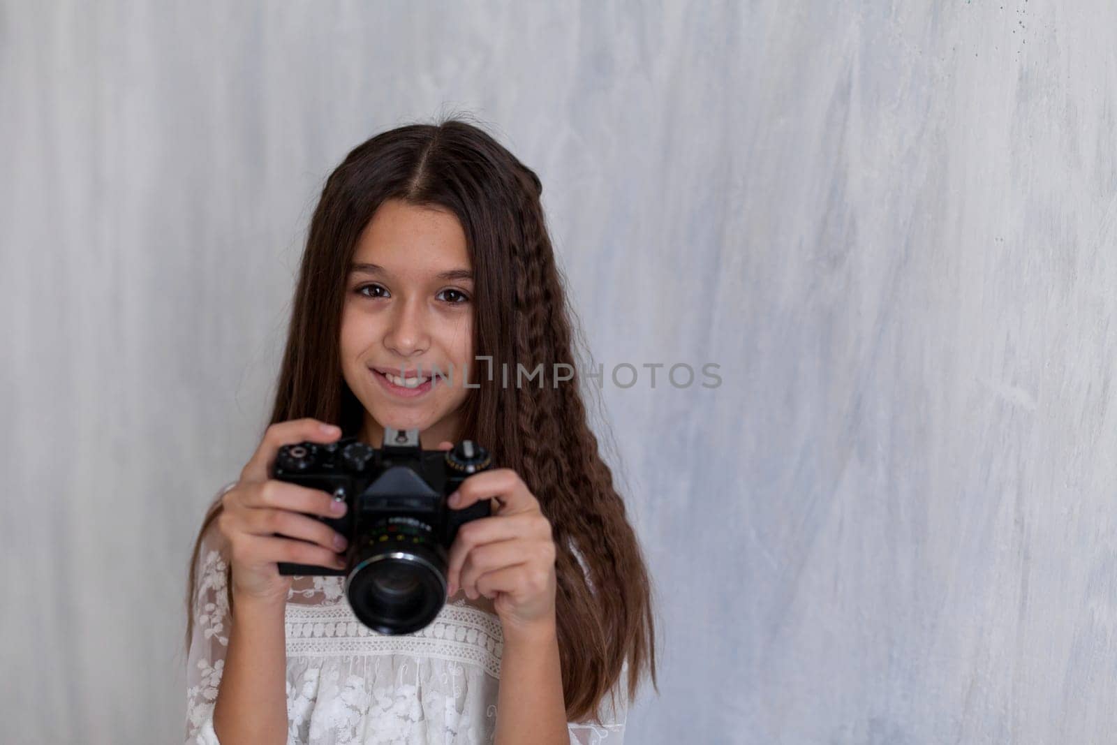 Portrait of a fashionable schoolgirl photographer girl with a camera