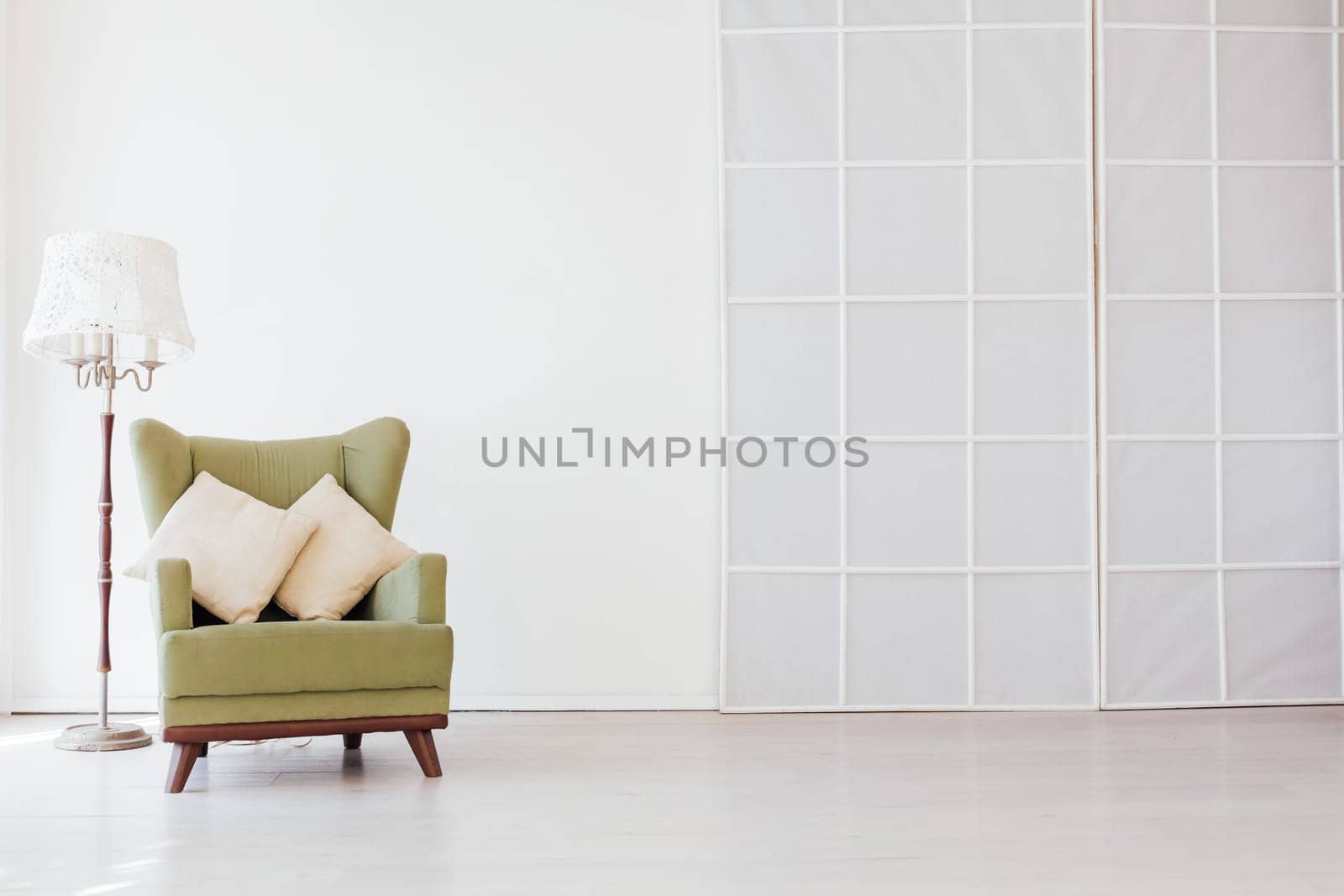 green vintage chair in the interior of an empty white room by Simakov