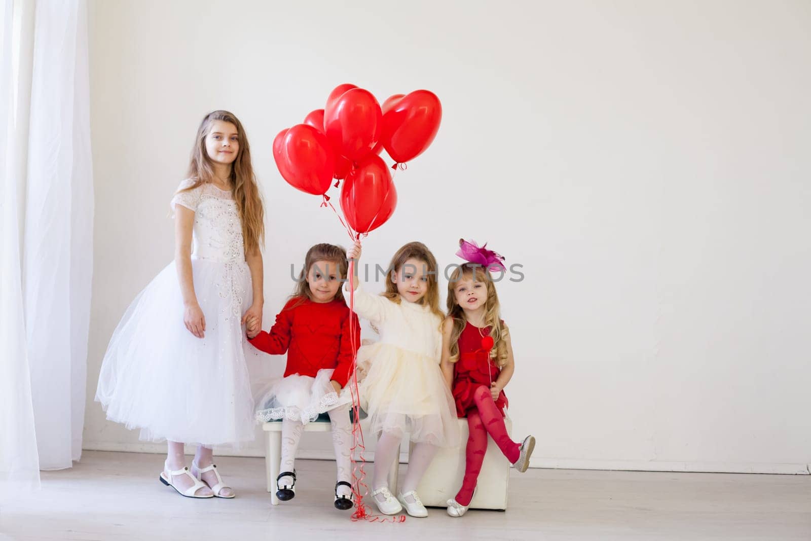 beautiful little kids with red balloons for the holiday by Simakov