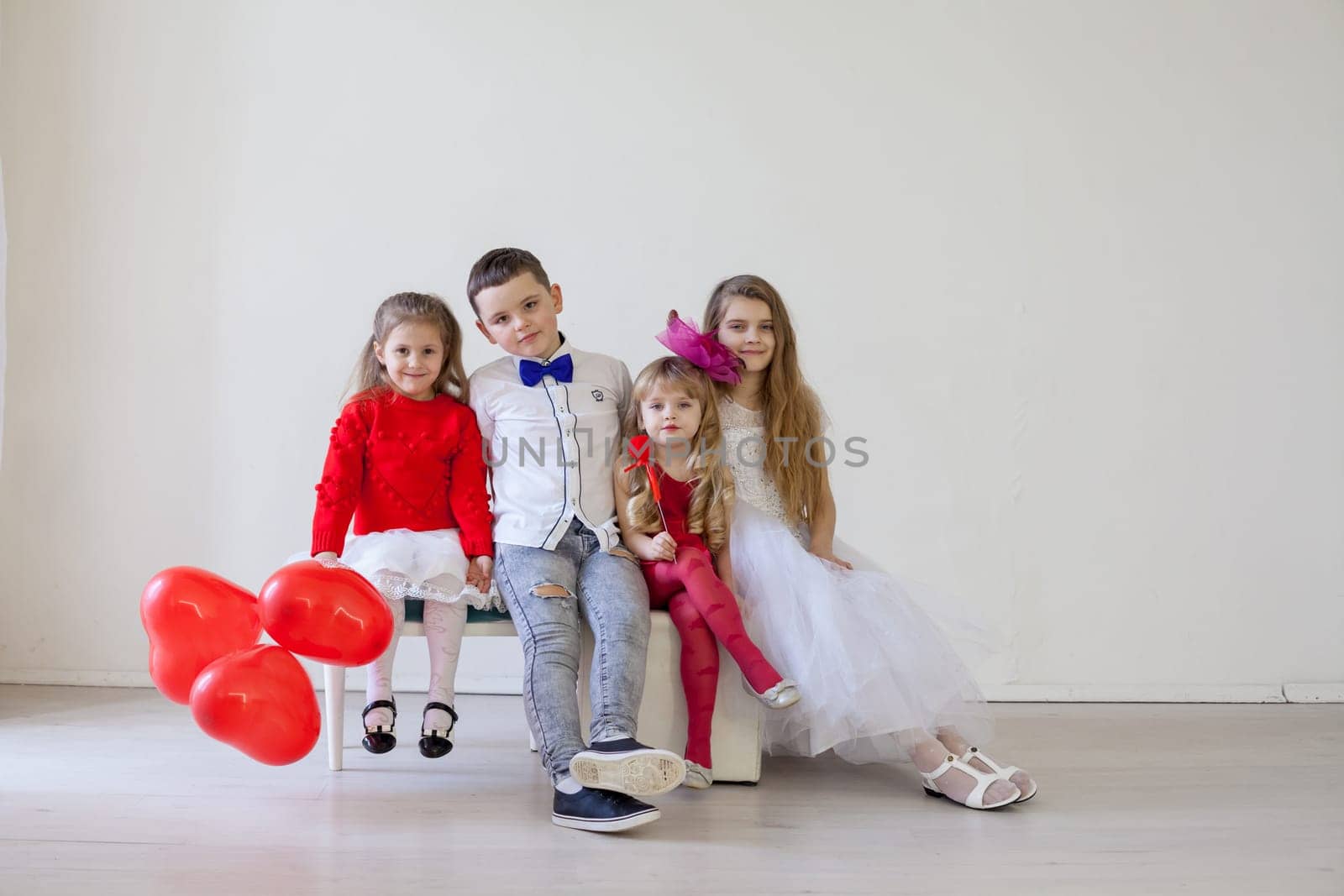 beautiful little kids with red balloons for the holiday by Simakov