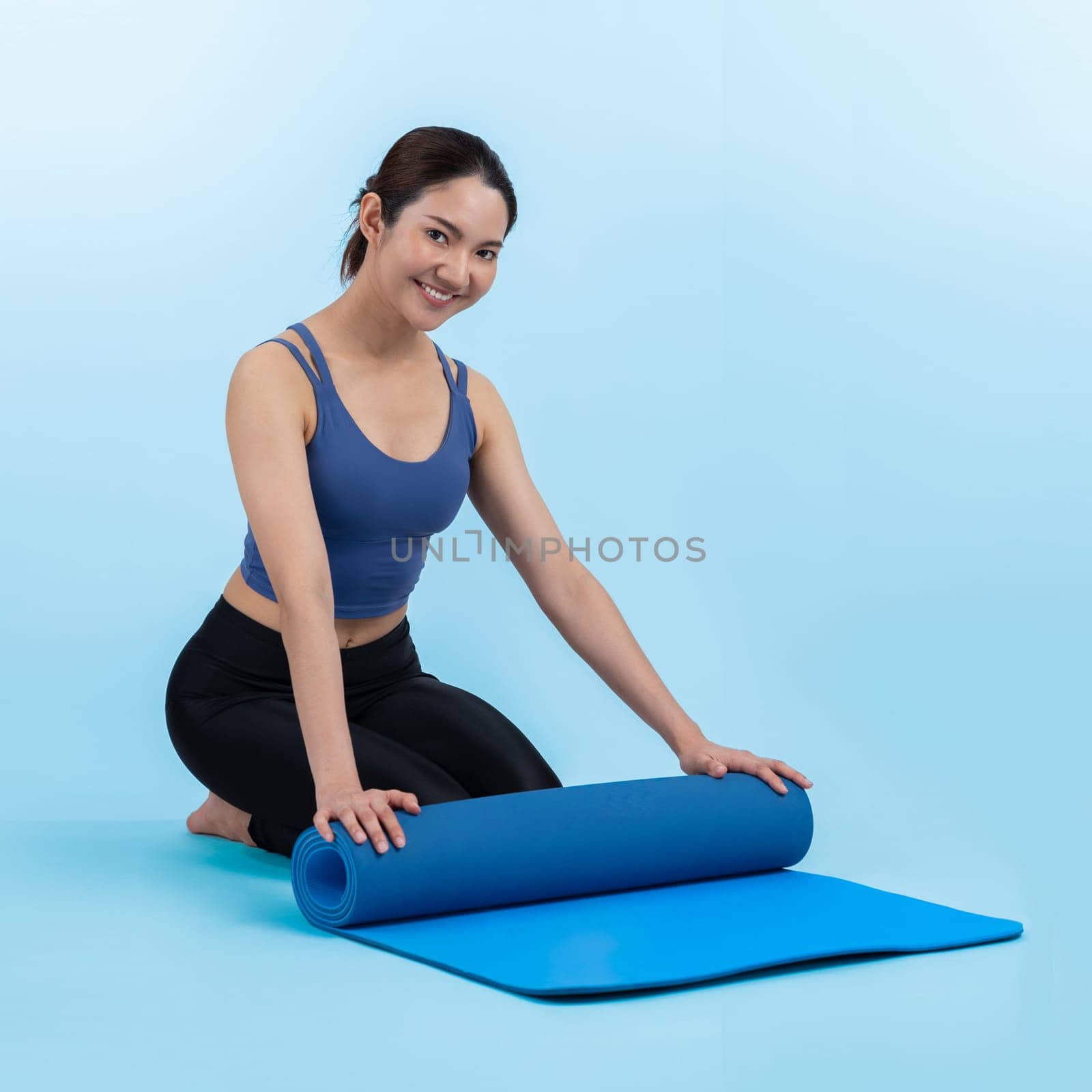 Young attractive asian woman portrait in sportswear with exercising mat. Healthy exercise and workout routine lifestyle concept. Studio shot isolated background. Vigorous