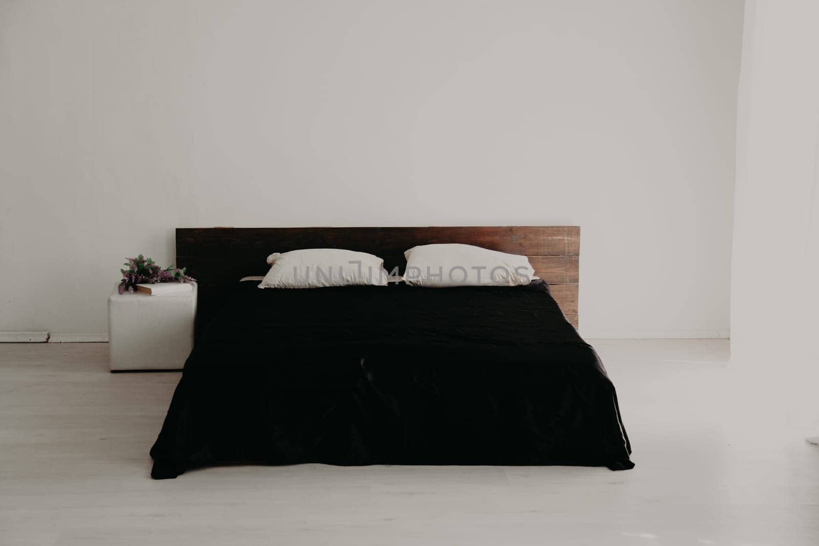 Interior white bedroom and bed with black sheets by Simakov