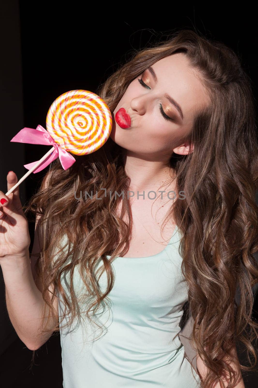 Beautiful woman eats a candy sweet lollipop