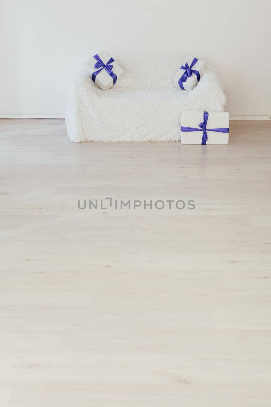 white sofa with lots of gifts in the inder of the empty room by Simakov