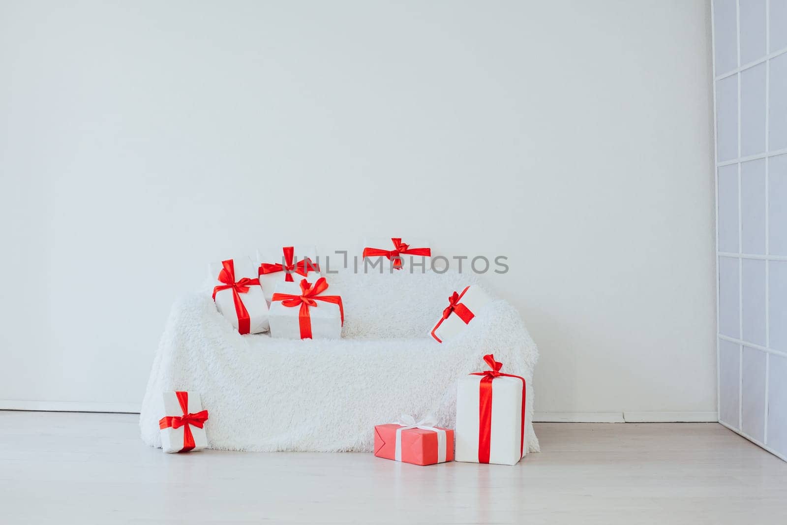 white sofa with lots of gifts in the inder of the empty room by Simakov