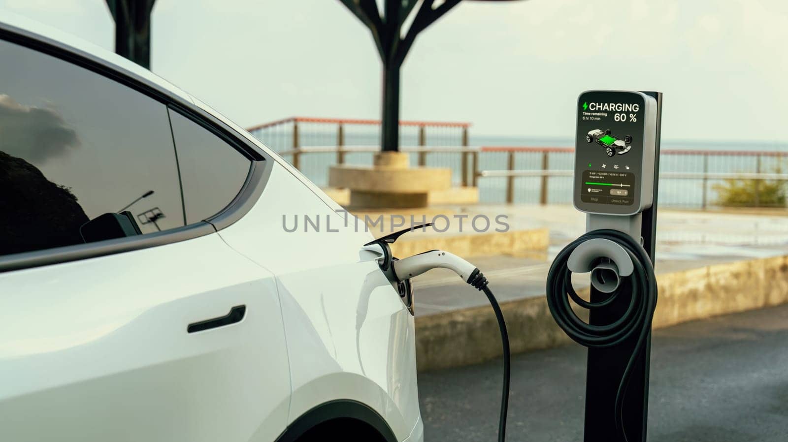 Electric car recharging battery at outdoor EV charging station. Perpetual by biancoblue