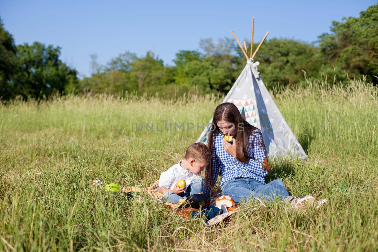 Mom and son eat on a picnic in the woods