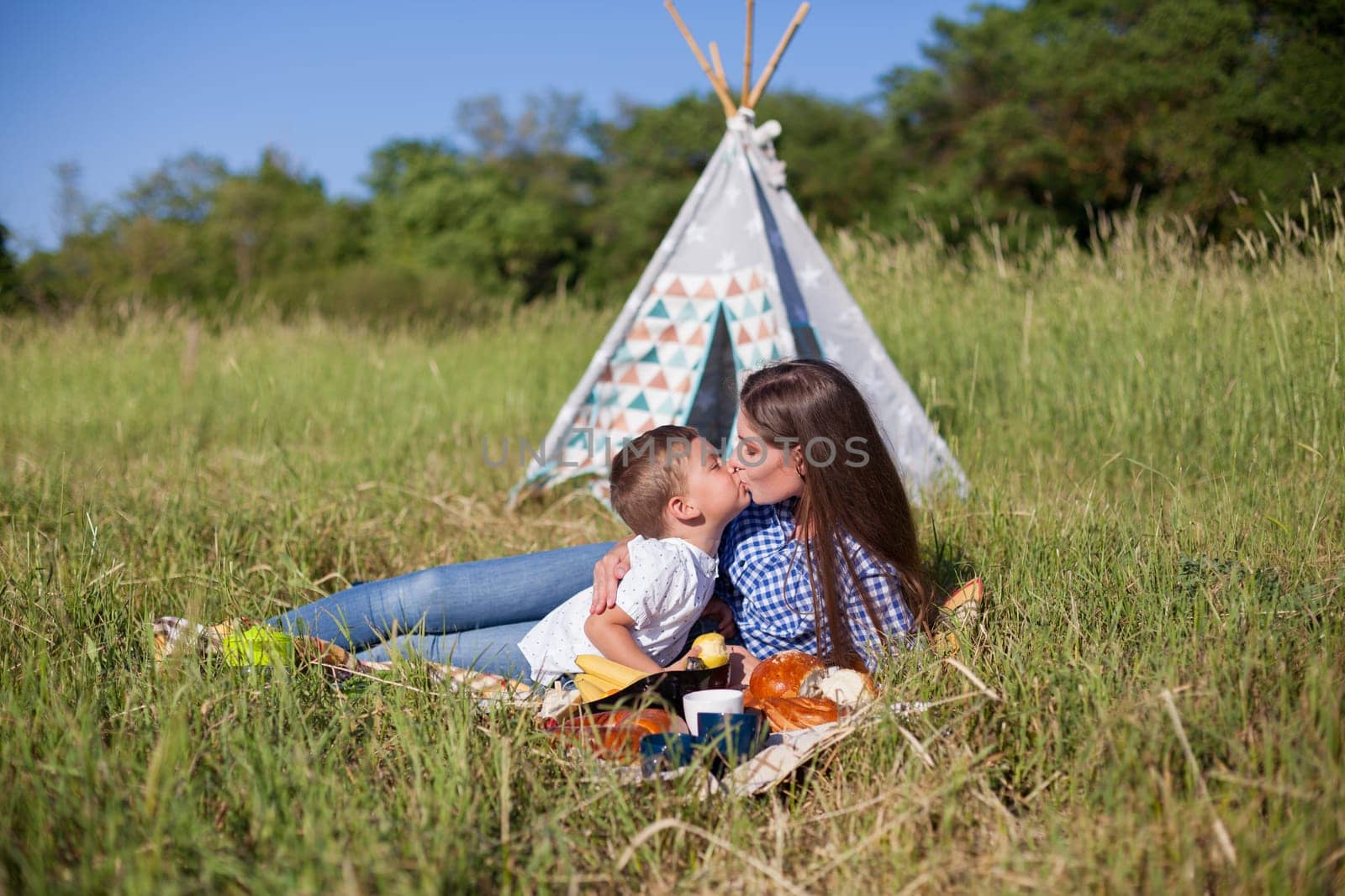 Mom and son eat on a picnic in the woods