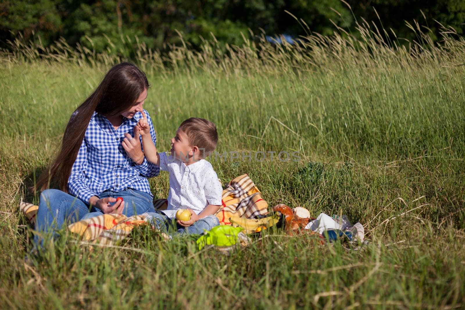 Mom and son eat on a picnic in the woods