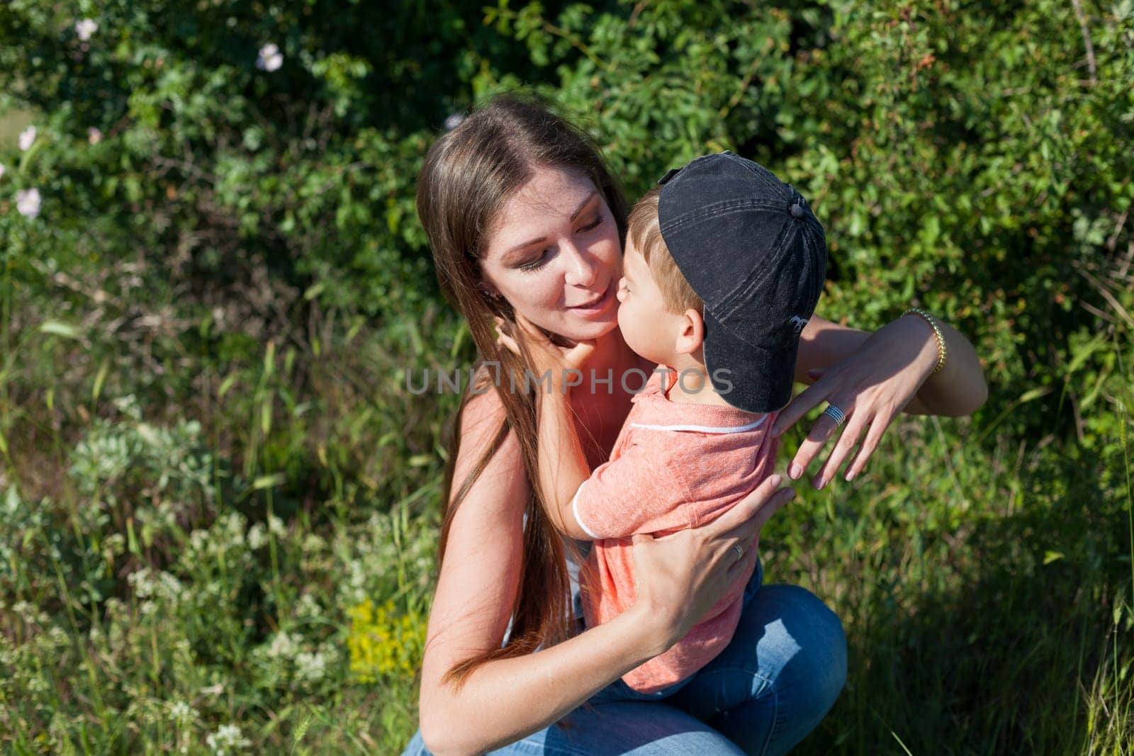 Mom with son playing in the garden on the grass