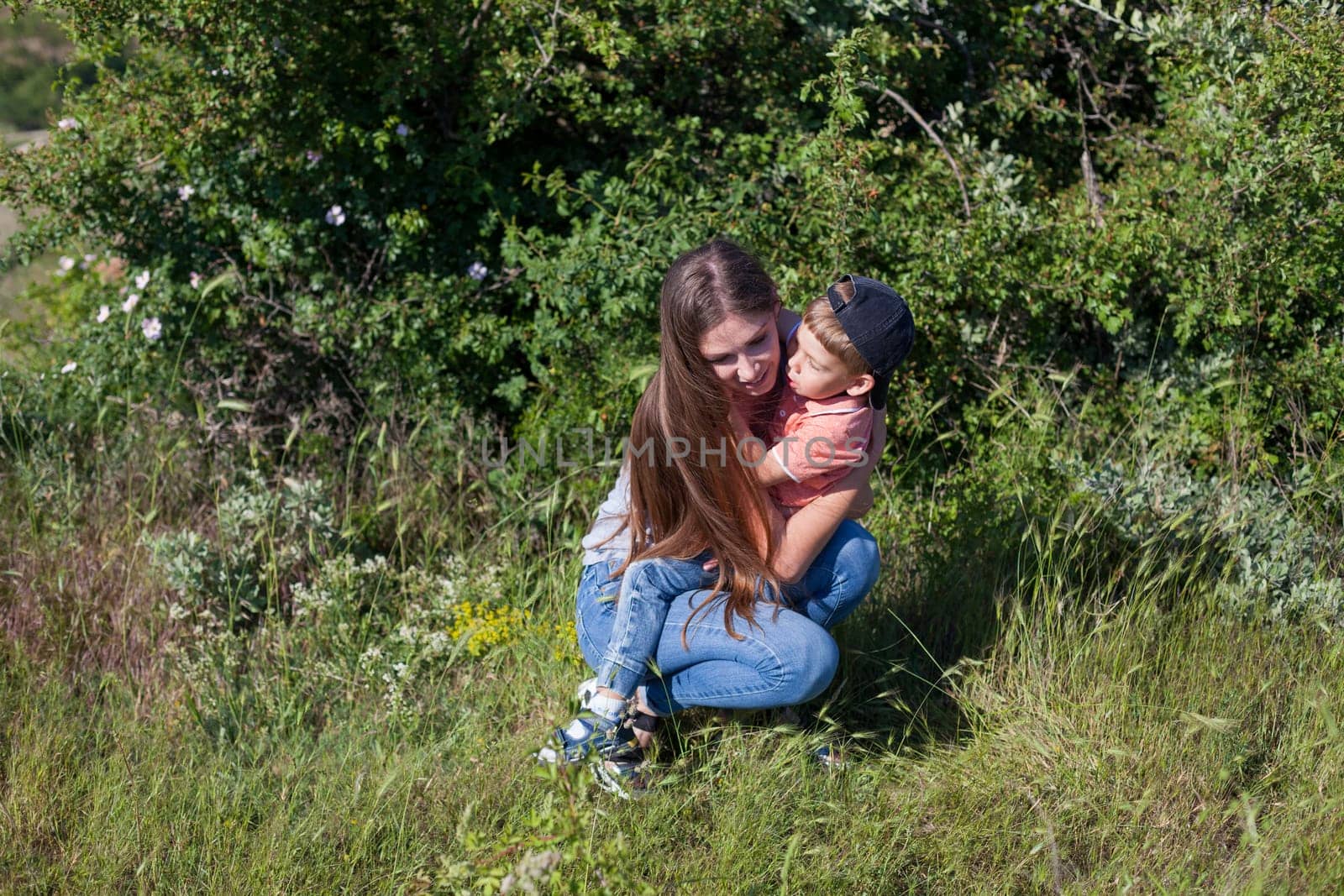 Mom with son playing in the garden on the grass