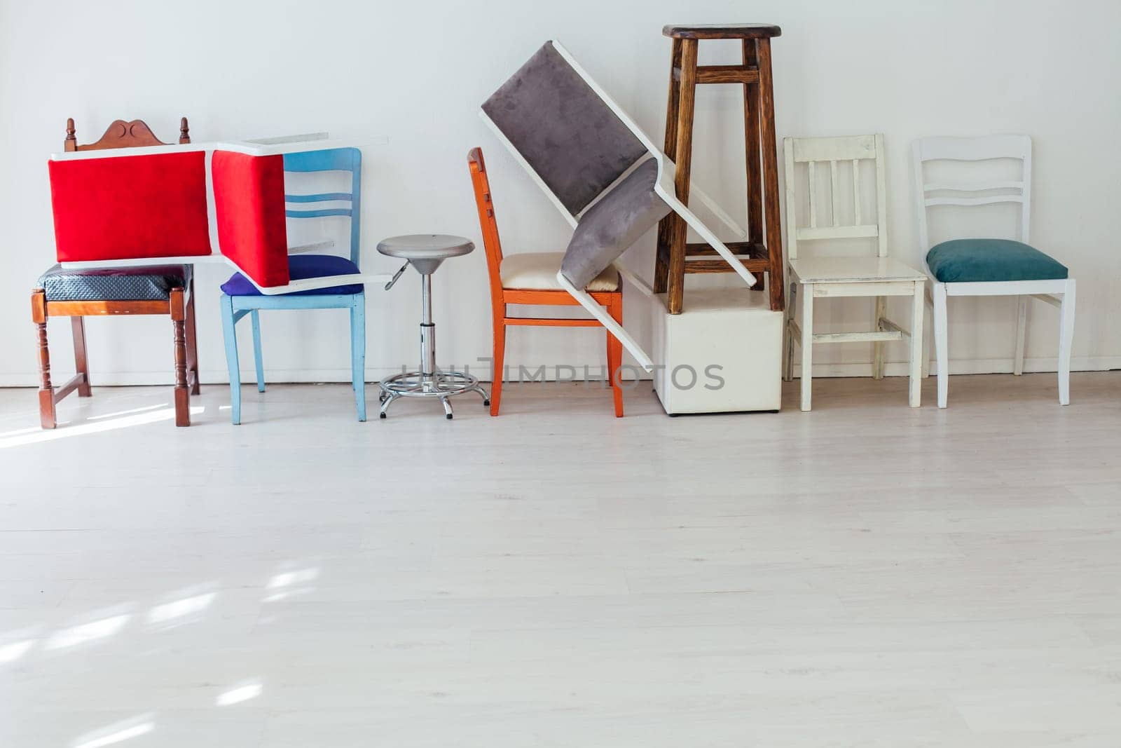 lots of different chairs in the interior of the white room moving