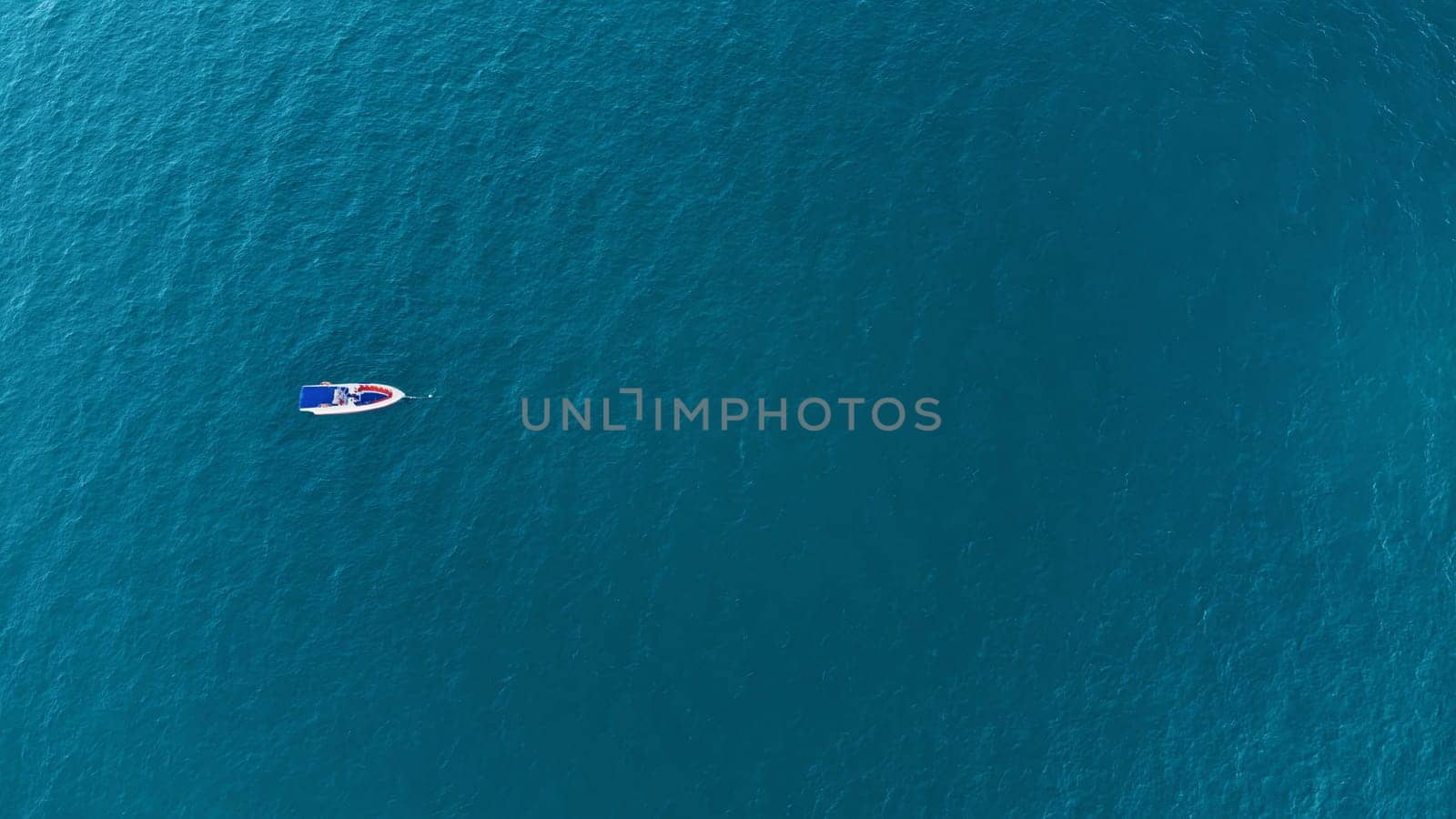 Aerial drone top down photo of speed boat anchored.