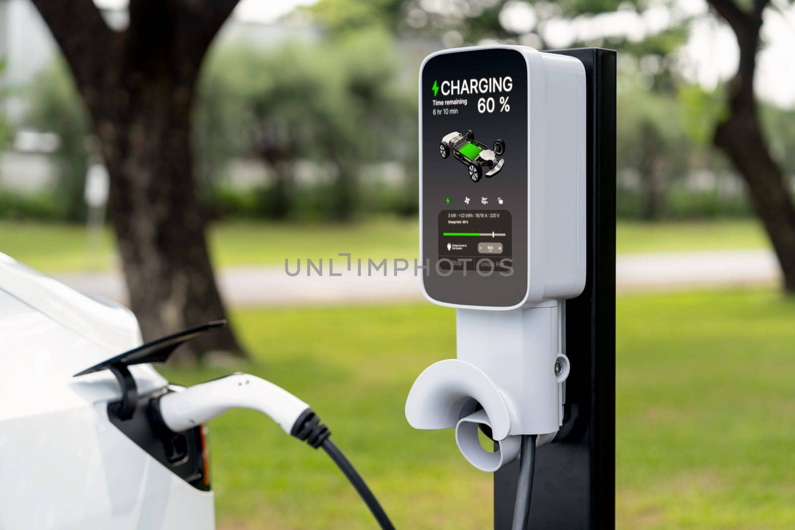 EV electric vehicle recharging battery from EV charging station in outdoor green city park scenic. Natural protection with eco friendly EV car travel. Exalt