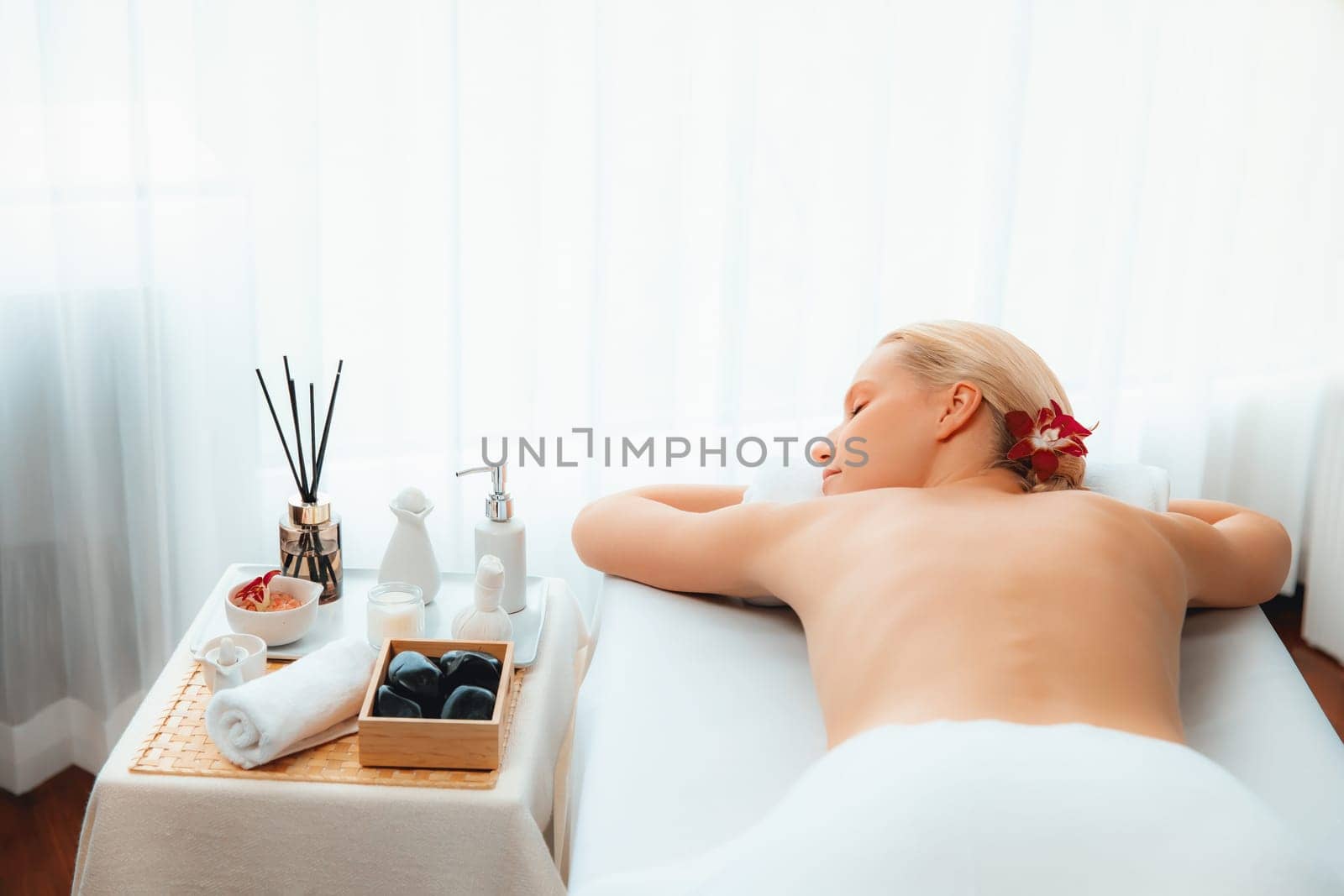 Caucasian woman customer enjoying relaxing anti-stress spa massage and pampering with beauty skin recreation leisure in day light ambient salon spa at luxury resort or hotel. Quiescent