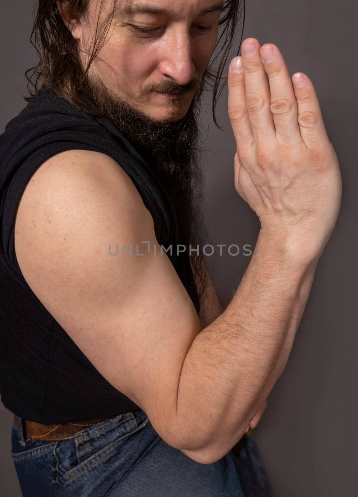 Sporty young man training against dark gray background. a man shows a wushu kick, a beautiful man's hand, Mockup for tattoos, jewelry, mehendi