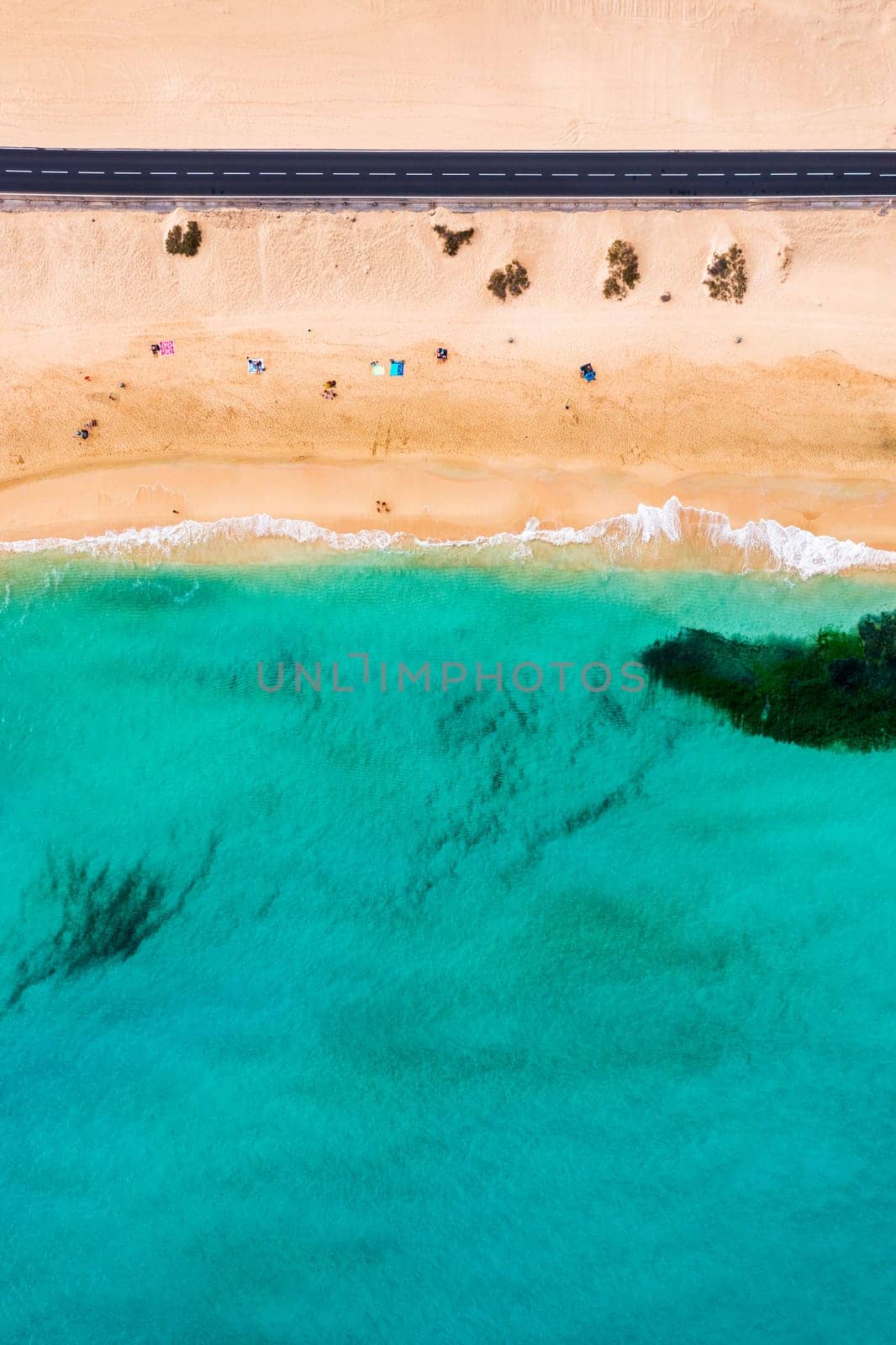 Beach with turquoise water on Fuerteventura island, Spain, Canary islands. Aerial view of sand beach, ocean texture background, top down view of beach by drone. Fuerteventura, Spain, Canary islands.