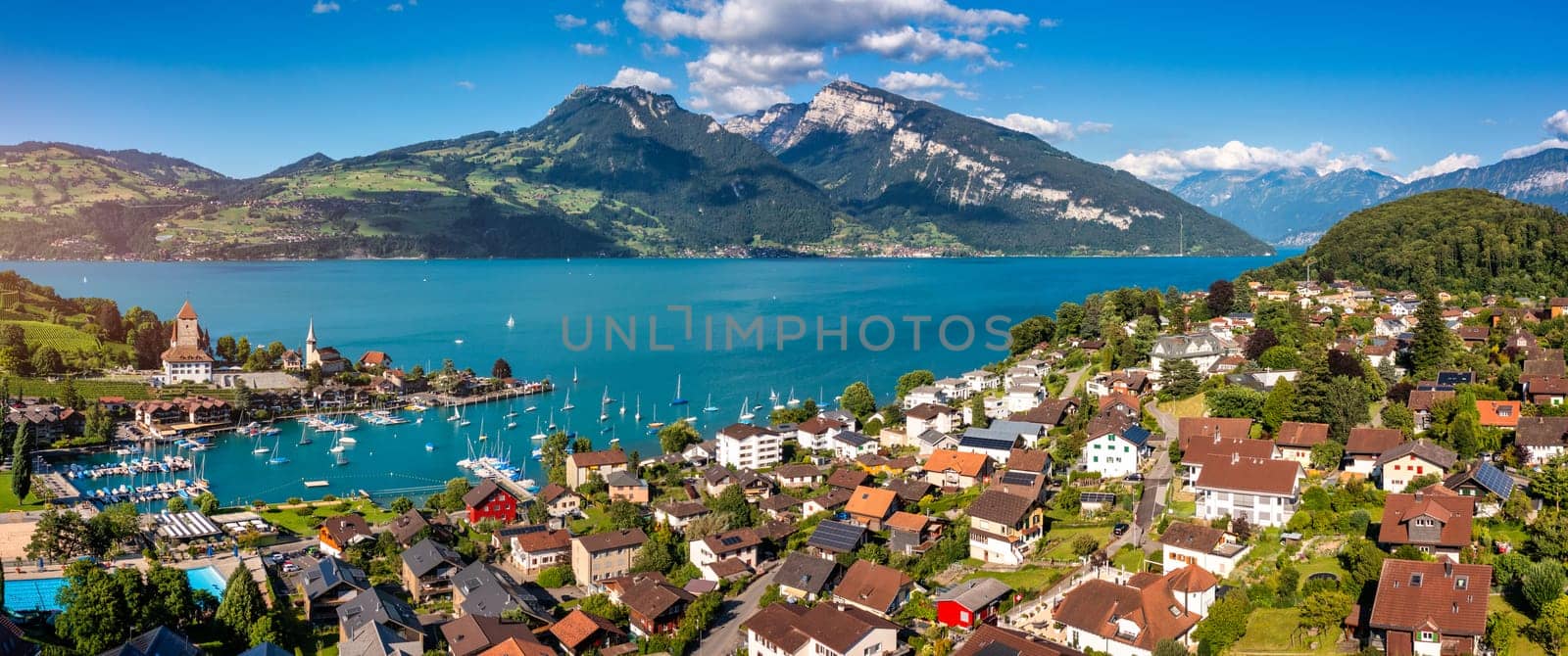 View of Spiez Church and town on the shore of Lake Thun in the Swiss canton of Bern at sunset, Spiez, Switzerland. Spiez city on lake Thun in the canton of Bern, Switzerland.