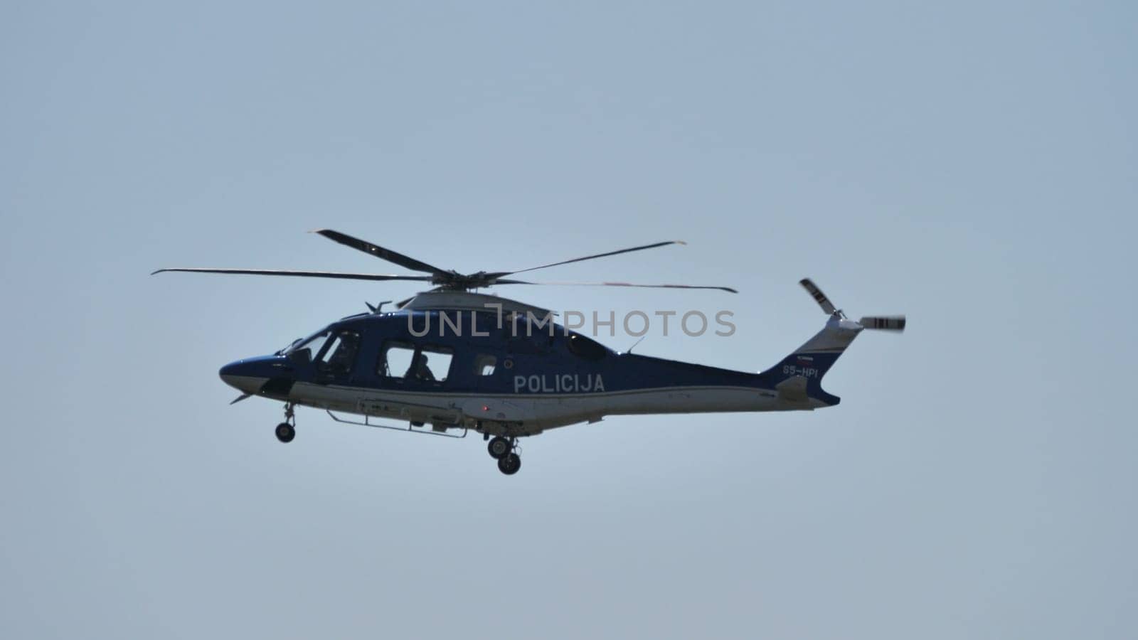 Police helicopter patrolling the area, with clear skies in the background, ideal for editorial use. Includes copyspace.