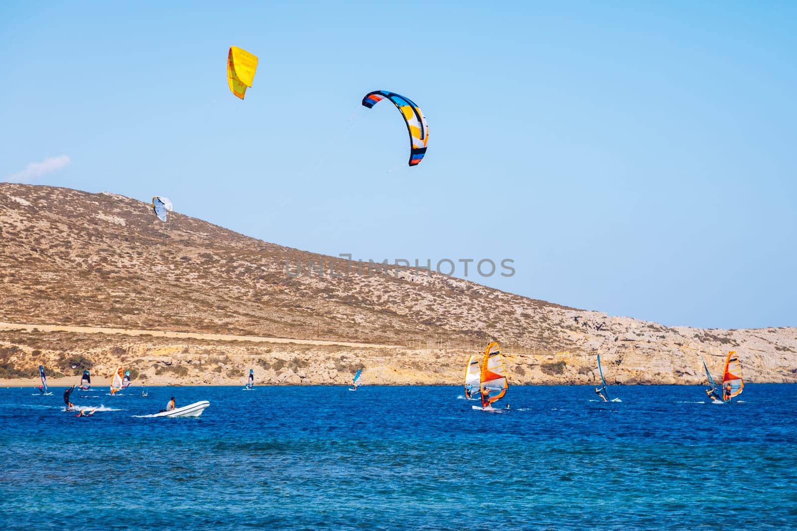 Surfers in Prasonisi Beach in Rhodes island, Greece. Kiteboarder kitesurfer athlete performing kitesurfing kiteboarding tricks. Prasonisi Beach is popular location for surfing. Greece