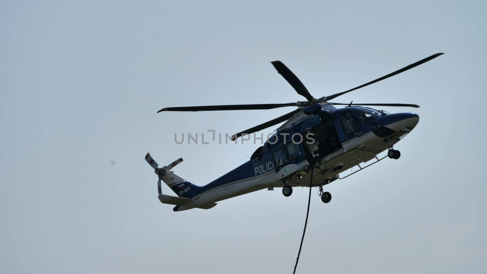 Police helicopter on aerial duty, with a clear sky backdrop, ideal for law enforcement themes, with copy space.