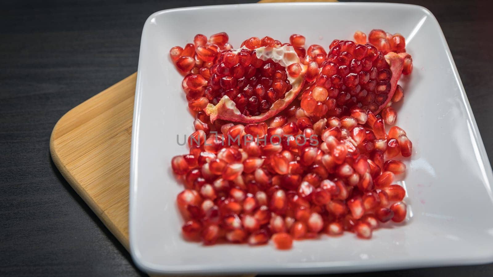 Ripe pomegranate fruit in a jar on wooden vintage background