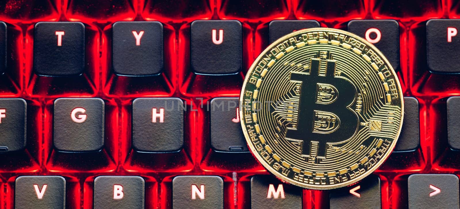 Bitcoin on compuer keyboard in background, symbol of electronic virtual money and mining cryptocurrency concept. Coin crypto currency bitcoin lies on the keyboard. Bitcoin on keyboard.