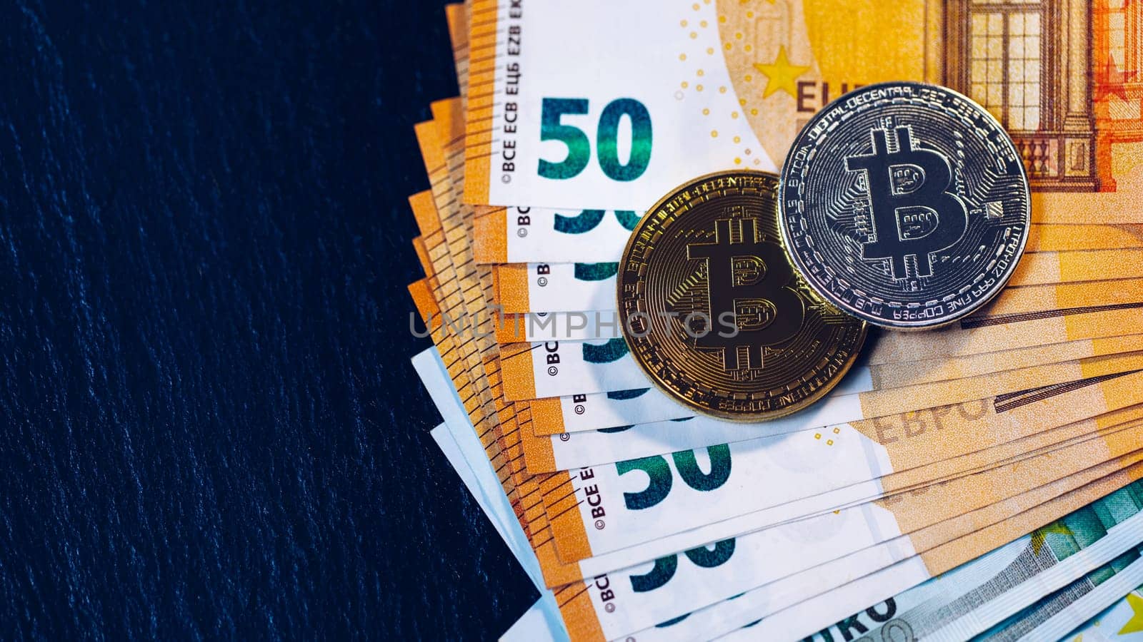 Golden bitcoin over Euro money. Bitcoin cryptocurrency. Crypto currency concept. Bitcoin with euro bills. Bitcoins stacked on euro banknotes.