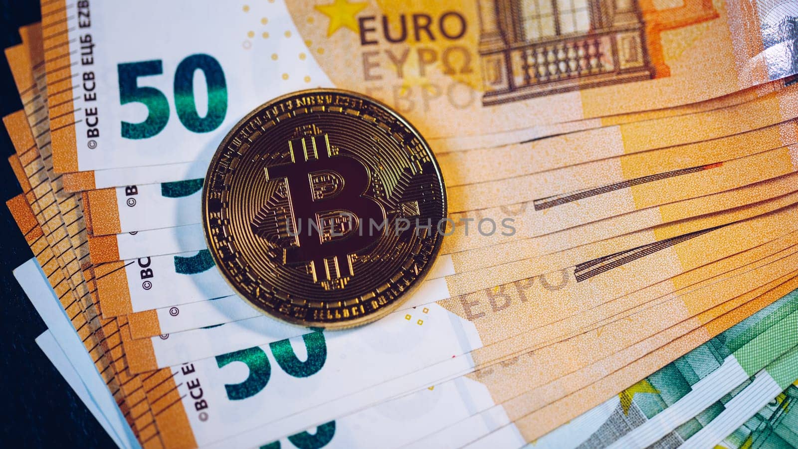 Golden bitcoin over Euro money. Bitcoin cryptocurrency. Crypto currency concept. Bitcoin with euro bills. Bitcoins stacked on euro banknotes.