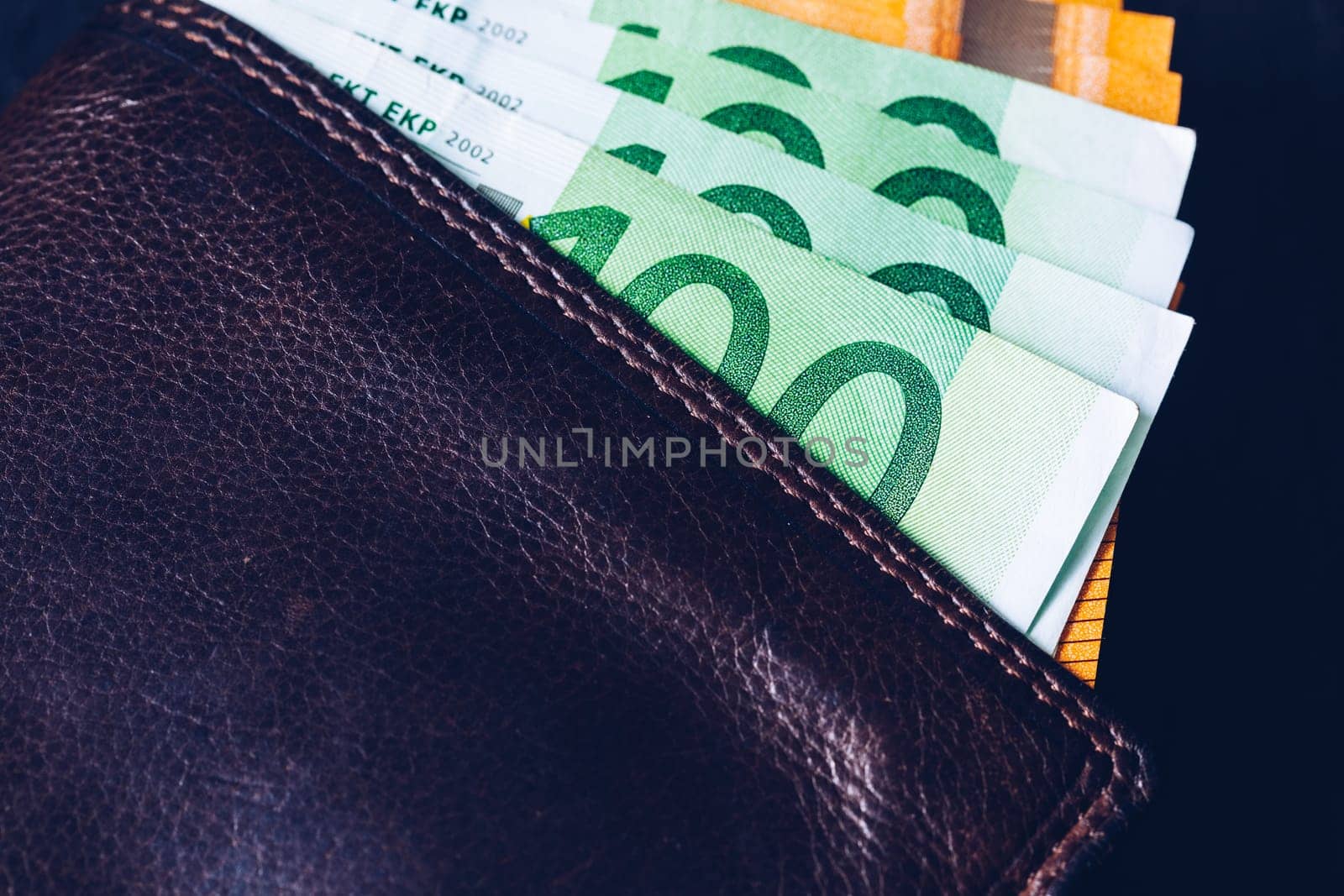 Wallet with Euro banknotes. Cash in the wallet on a black background. Euro money in leather wallet.
