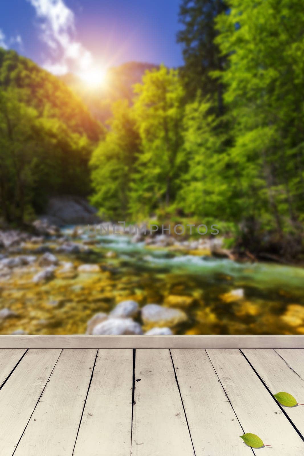 Empty wooden table for product placement or montage with focus to table top in the foreground. Mock up for display of product. Beautiful background with forest, waterfall, incredible landscape.