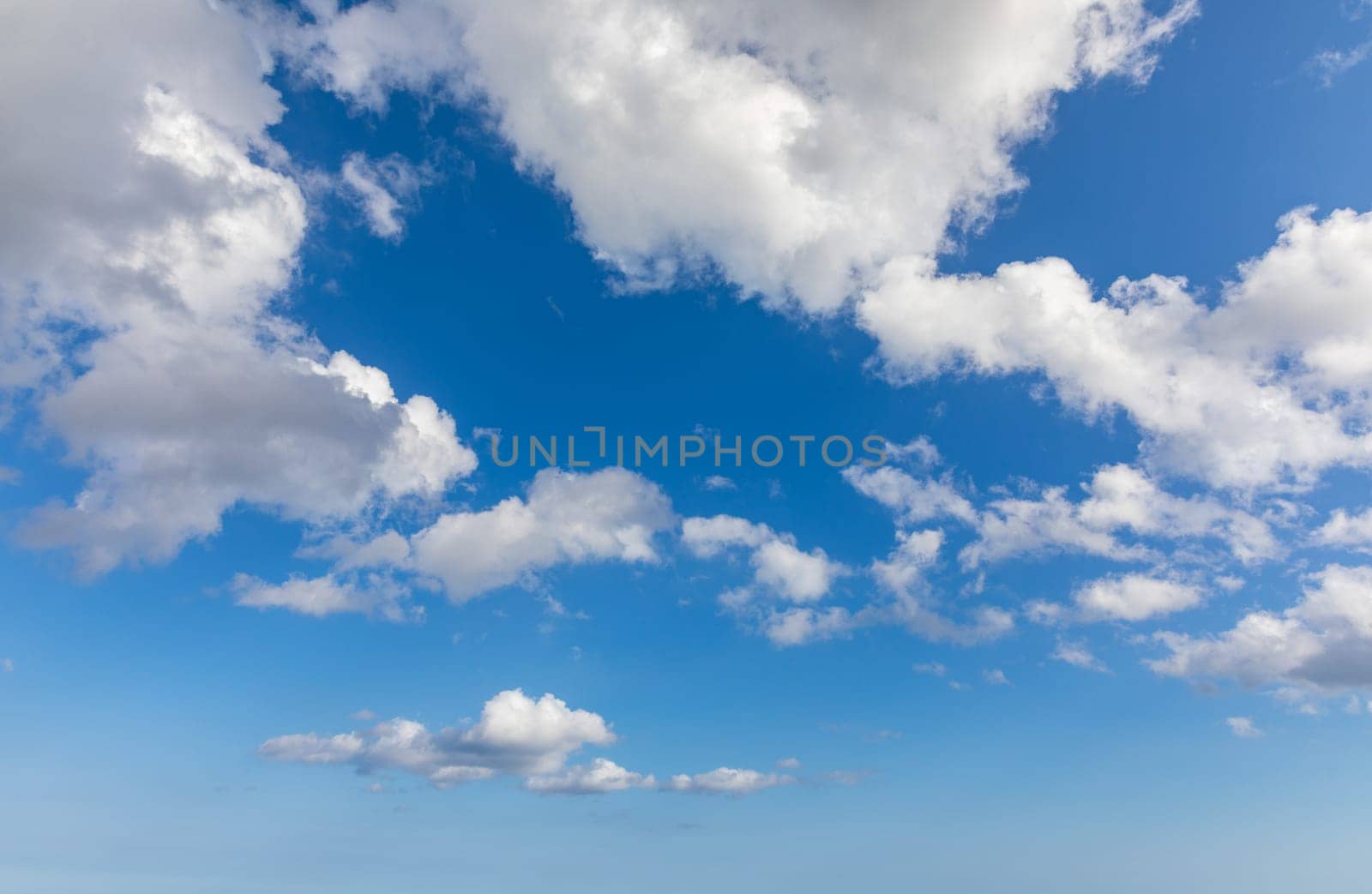 Sunny sky abstract background, beautiful cloudscape, on the heaven, view over white fluffy clouds, freedom concept. Aerial view of sky and white clouds. View from airplane. 
