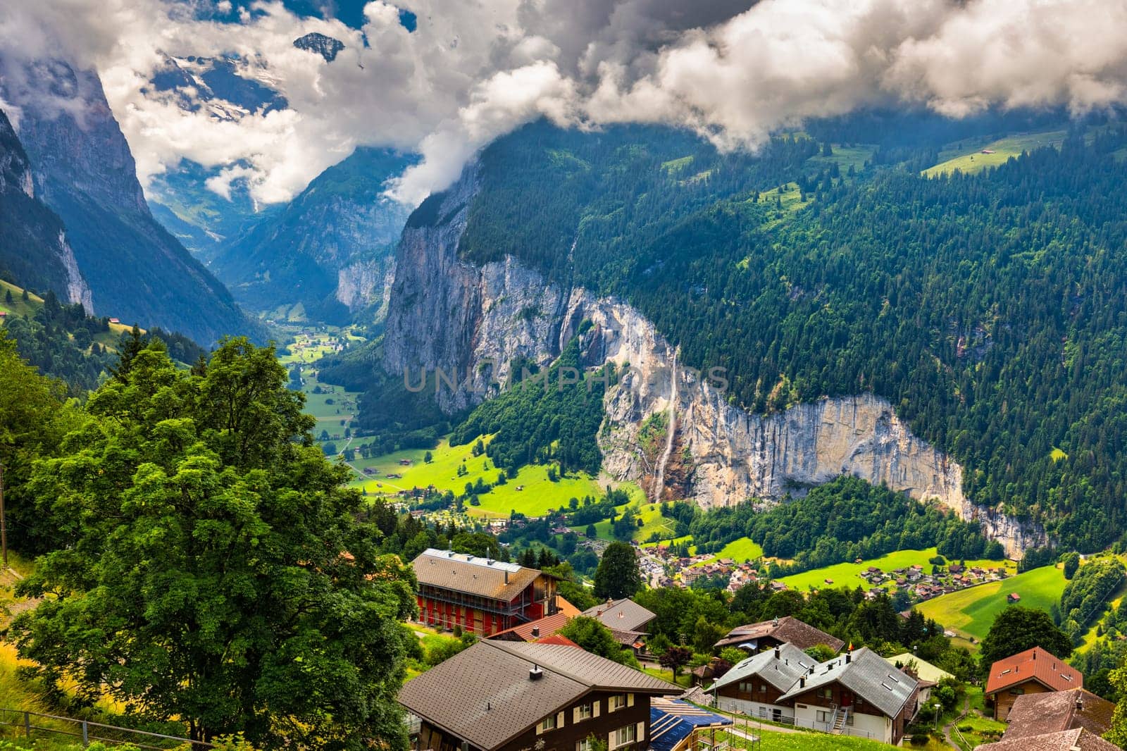Amazing summer landscape of touristic alpine village Lauterbrunnen with famous church and Staubbach waterfall. Location: Lauterbrunnen village, Berner Oberland, Switzerland, Europe. by DaLiu