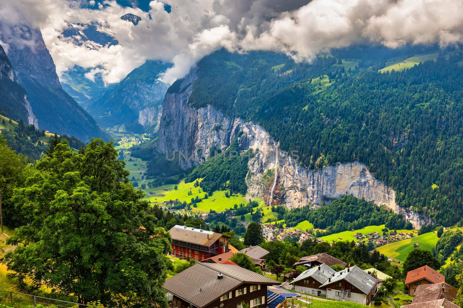 Amazing summer landscape of touristic alpine village Lauterbrunnen with famous church and Staubbach waterfall. Location: Lauterbrunnen village, Berner Oberland, Switzerland, Europe.