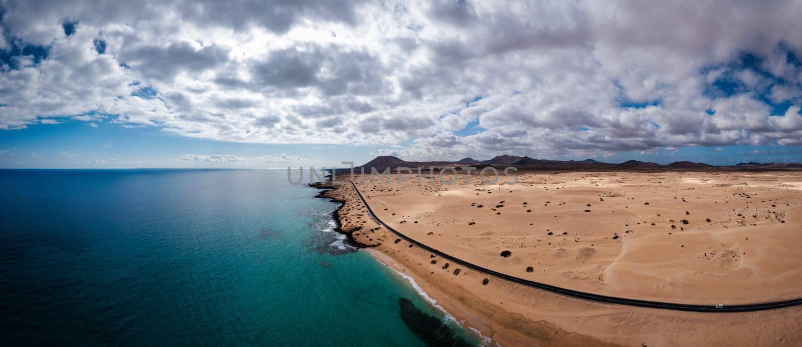 Panoramic high angle aerial drone view of Corralejo National Park (Parque Natural de Corralejo) with sand dunes located in the northeast corner of the island of Fuerteventura, Canary Islands, Spain.