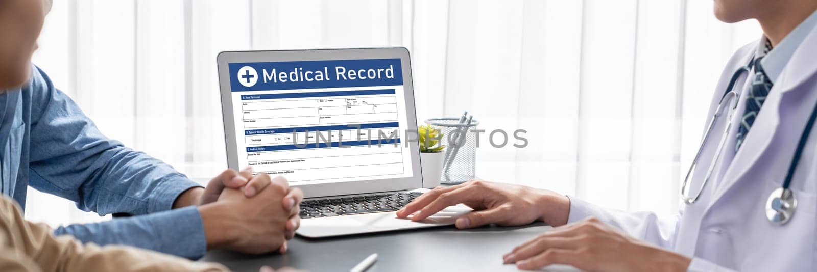 Doctor show medical diagnosis report on laptop and providing compassionate healthcare consultation while young couple patient holding hand and support each other in doctor clinic office. Neoteric