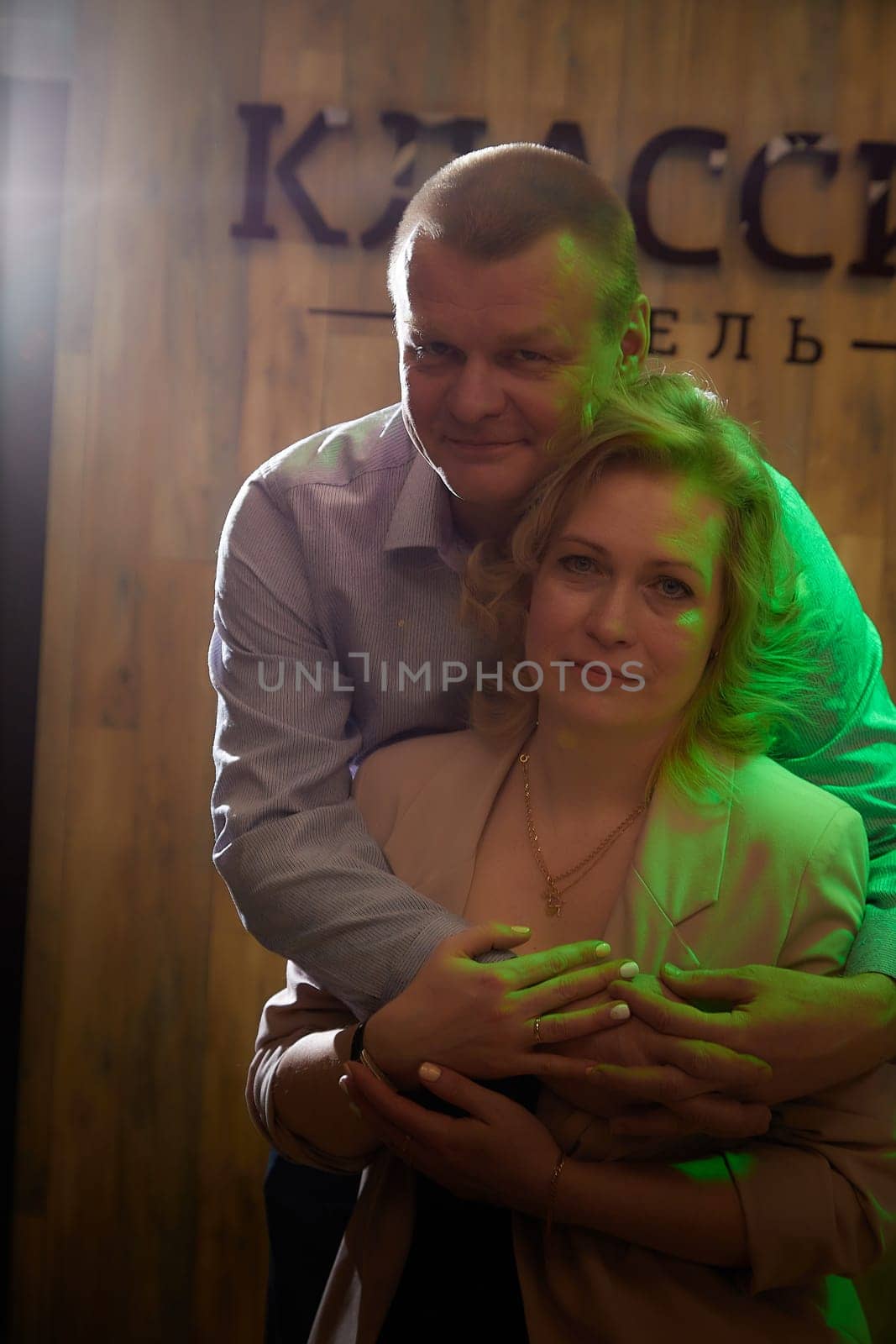 Adult man and woman are conversing on stage in dimly lit room before a performance or interview. The actors, actress, host, journalist, and paparazzi capturing their intimate, secretive conversation