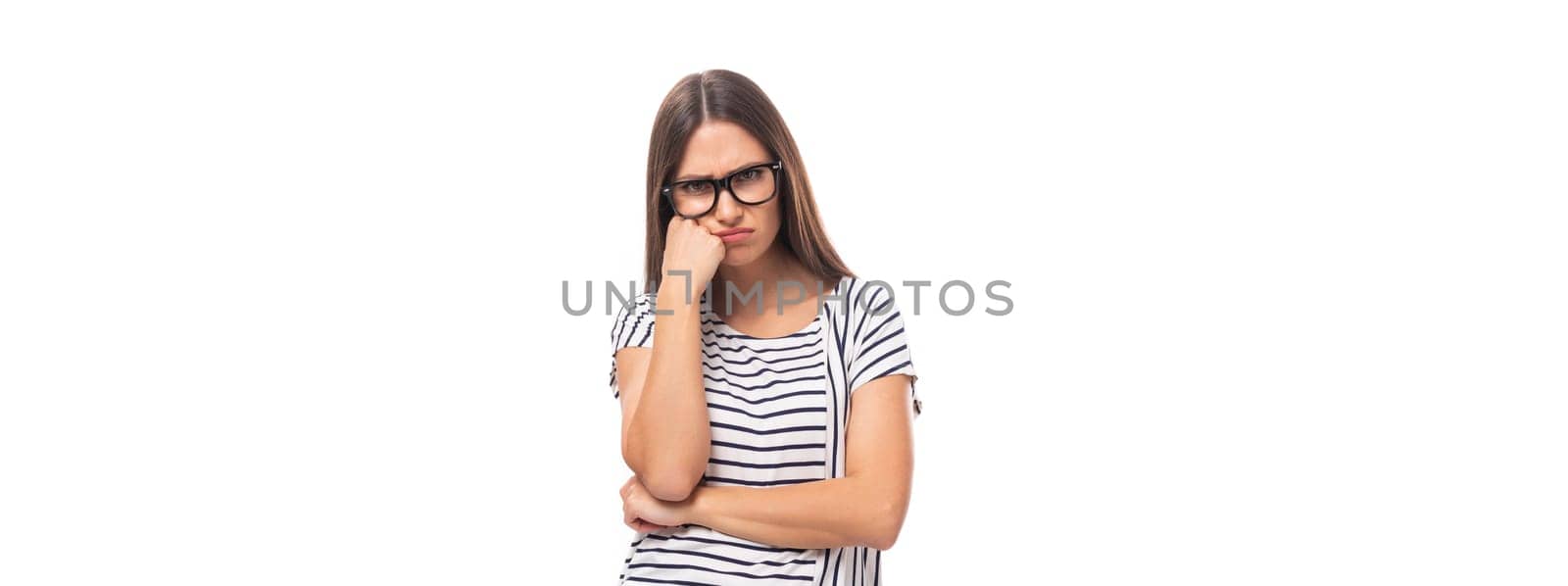 portrait of a young cute casual european woman with long dark hair dressed in a striped t-shirt on a white background with copy space.