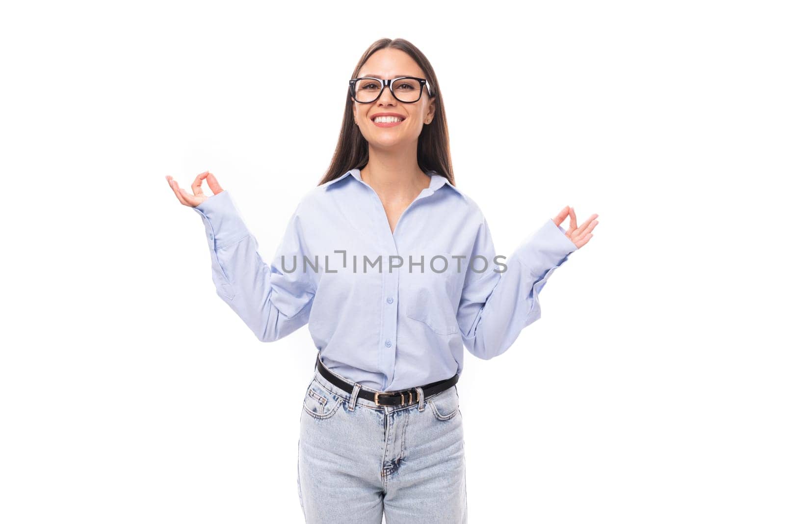 young pretty european brunette business woman with light makeup in a light blue blouse wears glasses for an image to work on a white background with copy space.