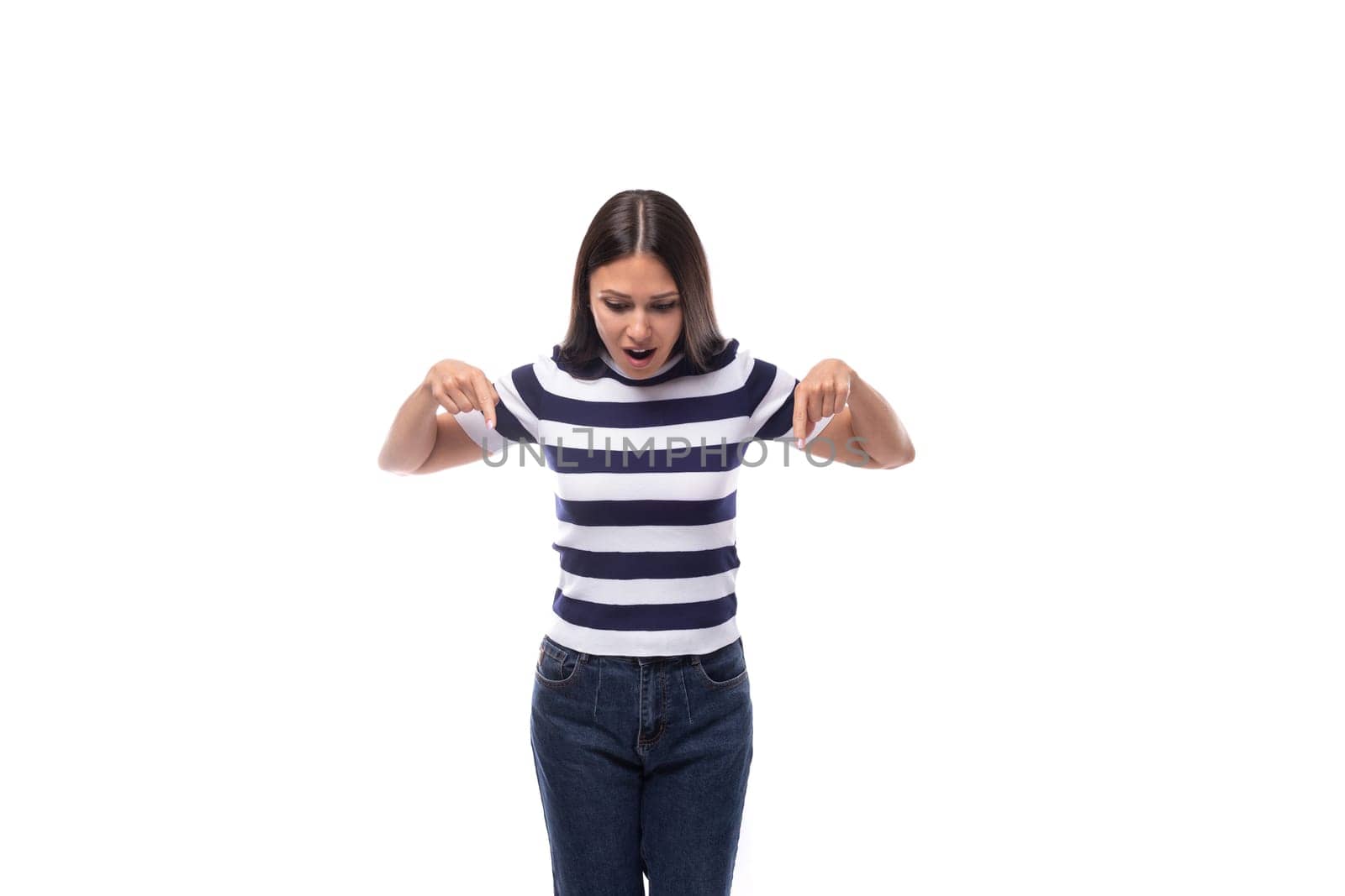 young european lady with black even hair dressed in a striped t-shirt points with her index finger for ideas and news.