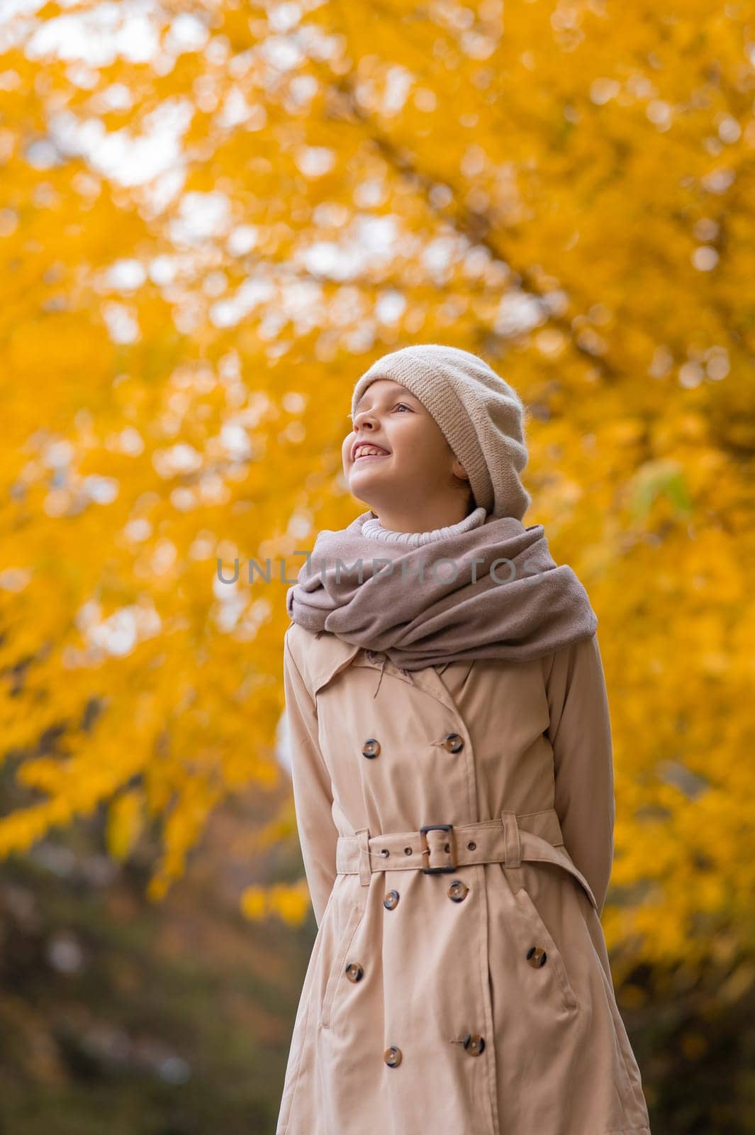 Caucasian girl in a beige coat and beret walks in the park in autumn. by mrwed54