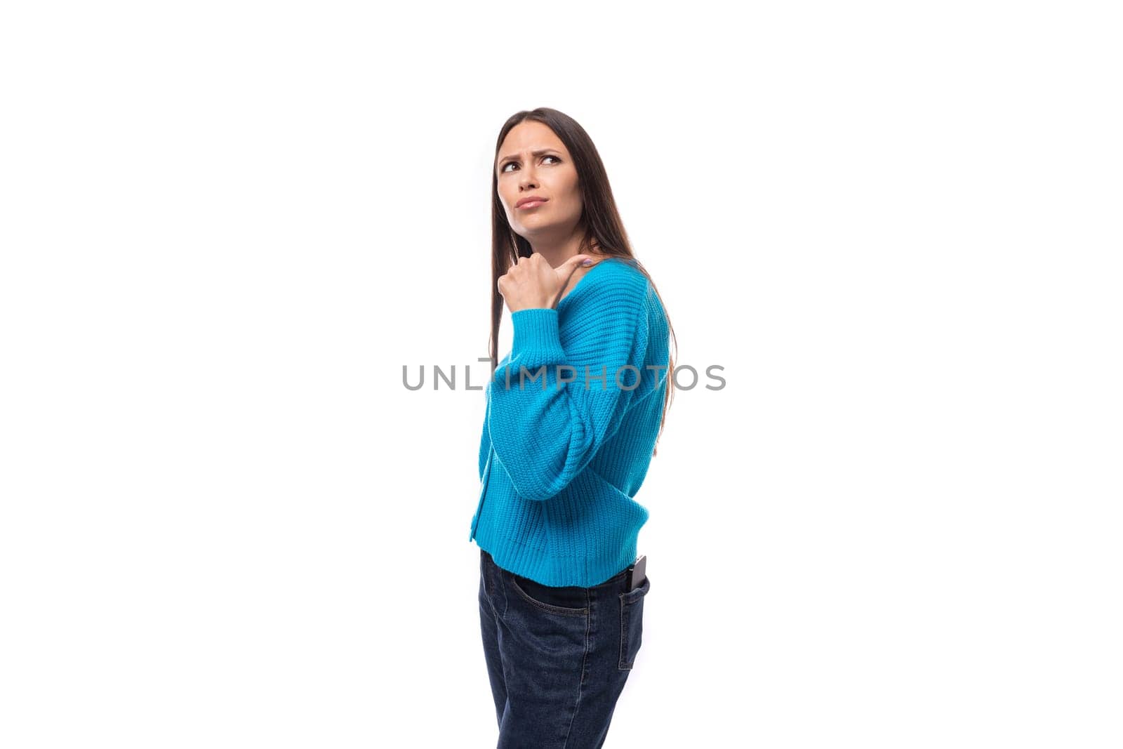dreamy stylish young brunette lady dressed in blue casual button up cardigan on white background with copy space.