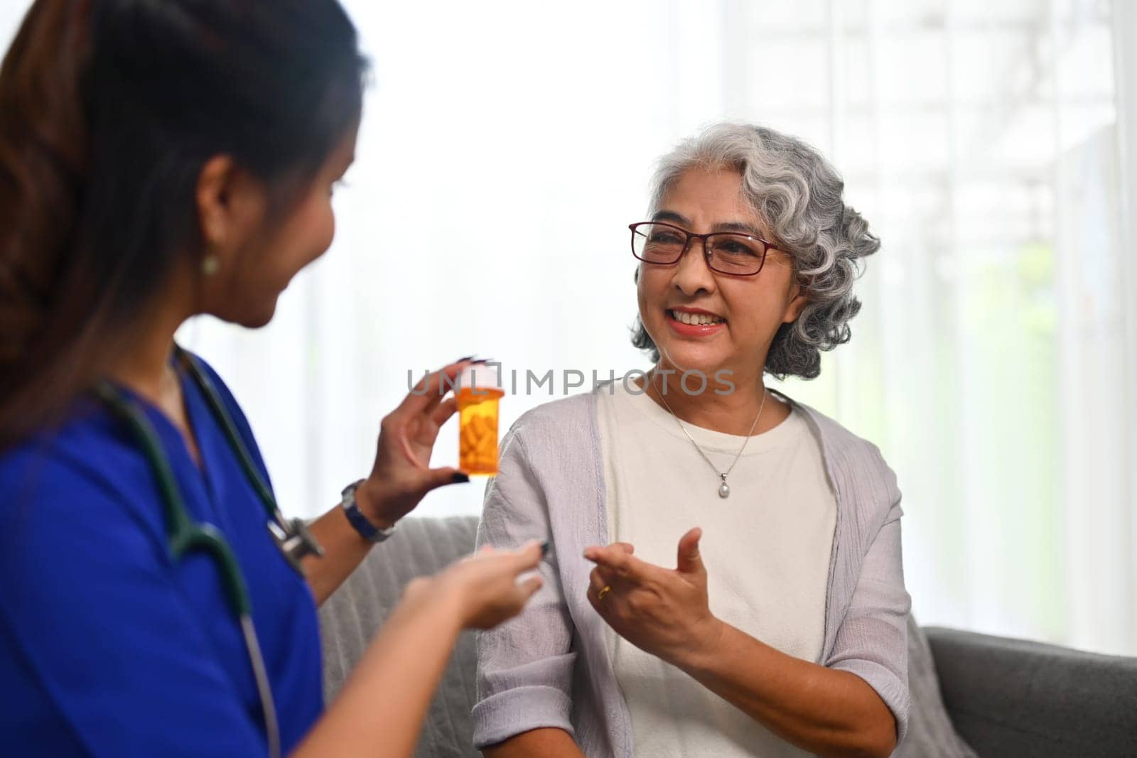 Young male health visitor explaining medicine dosage to senior patient. Elderly healthcare concept.