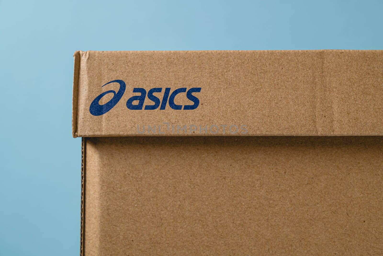 Antalya, Turkey - November 28, 2023: Sport shoe box with Asics logo printed. on blue background by Sonat