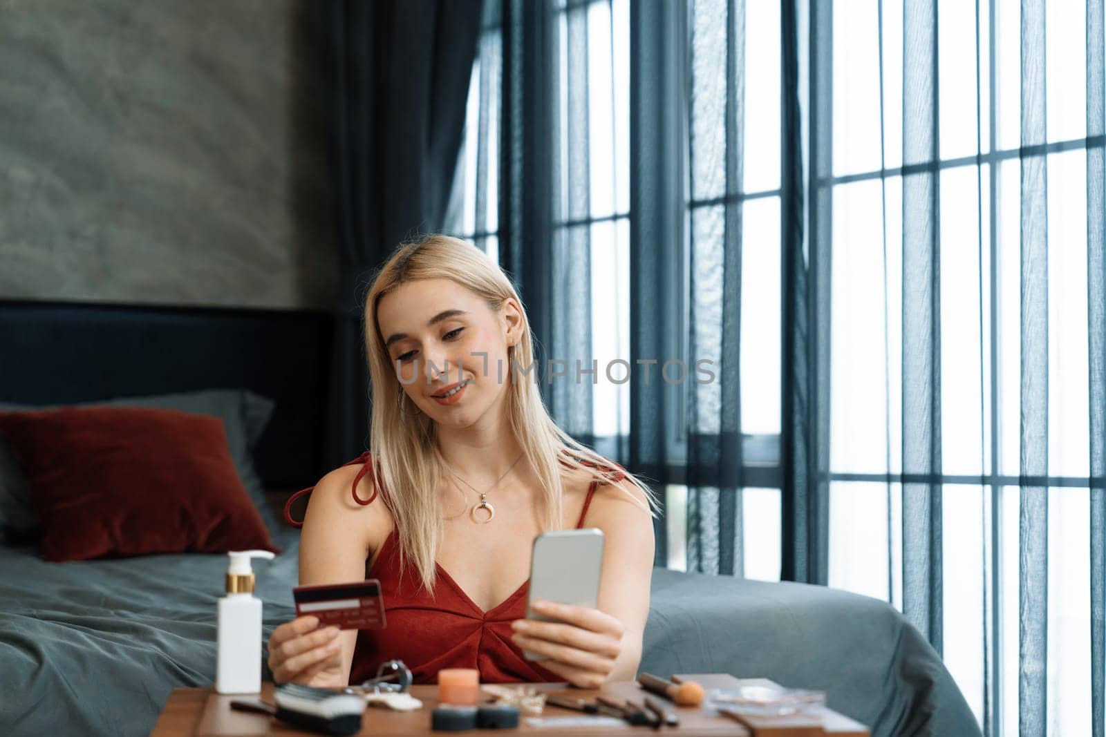 Young woman using online payment app and digital wallet on smartphone to pay with credit card. E commerce shopping and modern purchasing via mobile internet. Blithe