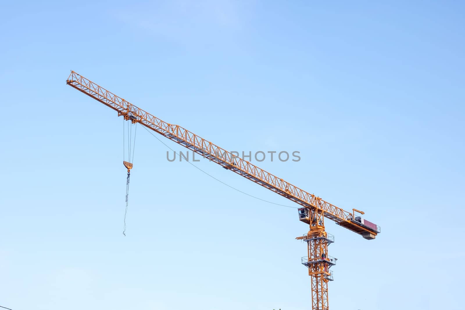 Construction crane on bright blue sky background by Vera1703